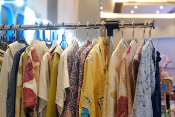 An array of Indonesian batik shirts and batik cloth hangs on the racks, displaying a variety of patterns and colors.