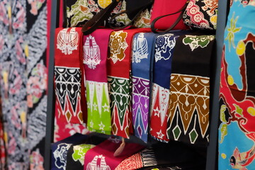 An array of Indonesian batik shirts and batik cloth hangs on the racks, displaying a variety of patterns and colors.