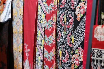 An array of Indonesian batik shirts and batik cloth hangs on the racks, displaying a variety of patterns and colors.