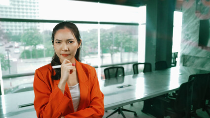 Professional young beautiful businesswoman thinking while standing at glass board with colorful...