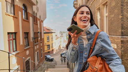 Woman using her smartphone in a colorful and sunny city environment.