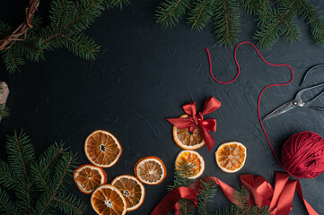 Christmas decoration and wrappung gifts on black background flat lay top view eco sustainable composition with pine branches and dried oranges copy space cute ribbons