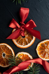 Christmas decoration and wrappung gifts on black background flat lay top view eco sustainable composition with pine branches and dried oranges copy space cute ribbons