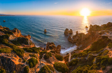 Aerial view of rock formation at Camilo beach in Algarve, Portugal during sunrise 