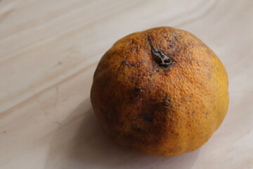 Una toma de cerca de una mandarina de color naranja con moho, en mal estado