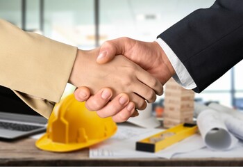construction worker with contractor shaking hands in renovation site.
