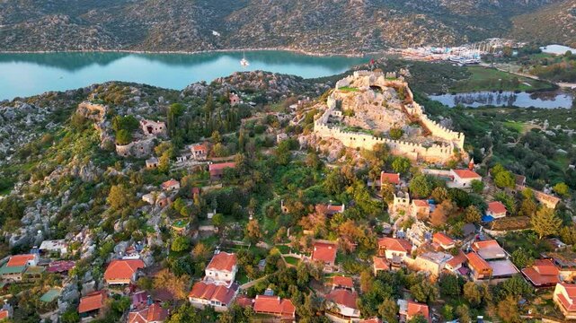 Aerial drone footage of Simena Castle and Kalek&ouml;y Village, Antalya Province, Turkey, overlooking the Mediterranean coast at sunset.