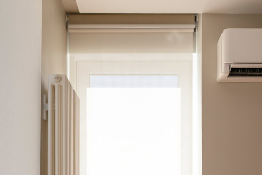 Roller blinds double system on the window. Blackout shade and sunscreen curtain. Motorized roller blinds for smart house. The screen fabric softly diffuses sunlight. Close-up, detailed photo.