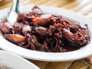 Style stir fried squid with black ink sweet sauce on white dish