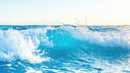 Blue ocean wave splashing in sunlight creating a dynamic and refreshing water scene against a clear sky background
