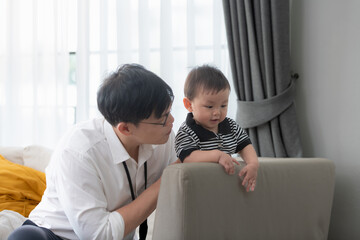 Father and son play together after dad comes home from work