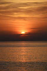 Fototapeta premium Orange Sunset Gradient over Calm Ocean Waters with Vibrant Sky