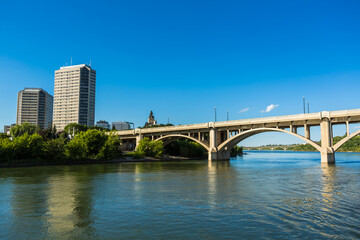 A bridge spans a river with a city in the background