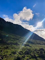 A serene evening view at the top of the mountain, where the majestic mountains meet the peaceful sky. The soft colors of the sun cast a magical glow on the ground, creating a perfect harmony