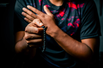 Man Praying with Rosary Beads