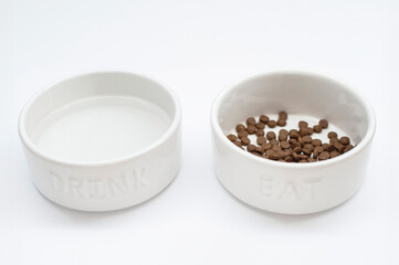 Minimalist set of two dog bowls labeled "Eat" and "Drink" on a crisp white background, designed for feeding and hydrating small breeds like Yorkshire Terrier puppies. 