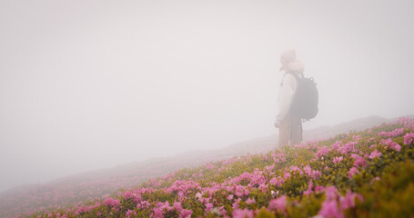 Difficult climbing female explorer in the misty mountains. No view from the mountain cliff but fog...