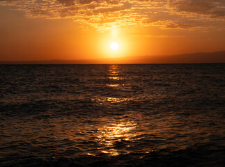 Beautiful sunrise over the sea, morning with feather clouds and yellow sky