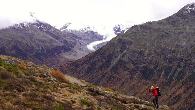 A man hiking in the mountains above Pontresina, in autumn.