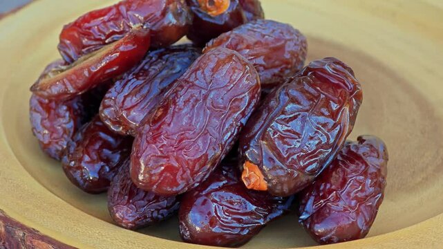 Fresh dried dates fruit in wooden plate.