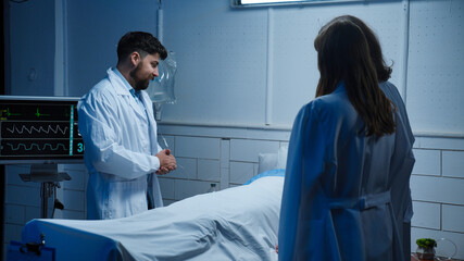 Obraz premium Adult man patient laying in hospital bed, ready to discharge, friends visiting and talking, doctor came to talk about results, positive expression.