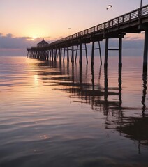 Fototapeta premium A serene reflection of the pier in the calm waters of the Baltic Sea at dawn , ripples, sky, reflection