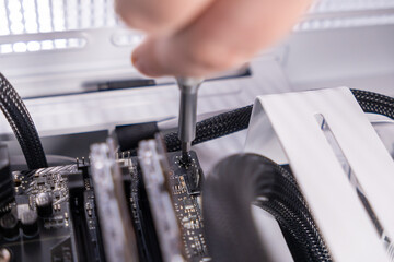 installing motherboard, screwdriver, hand securing screw, pc assembly, computer build, hardware...