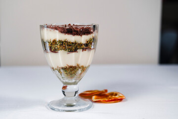 Magnolia dessert in cup composed with dubai style chocolate, pudding and bitter chocolate