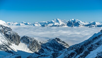 Naklejka premium 산꼭대기 풍경 눈으로 덮인 산봉우리와 그 아래로 펼쳐진 운해