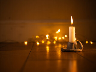 Candle in candlestick holder Christmas lights bokeh