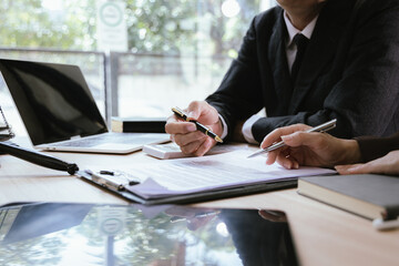 Close up of male lawyer working with contract documents and wooden hammer on table in courtroom....