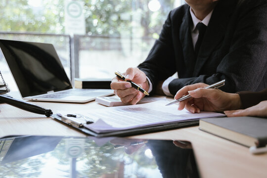 Close up of male lawyer working with contract documents and wooden hammer on table in courtroom. Justice and law. Judge in suit or lawyer working with documents. Law. Close up.