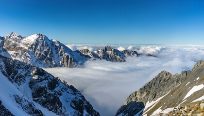 산꼭대기 풍경 눈으로 덮인 산봉우리와 그 아래로 펼쳐진 운해