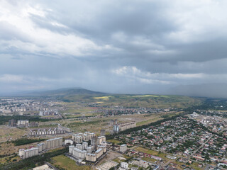 Mountain landscape in summer before the rain. City near the mountains. Top view, drone photo.