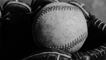 Nostalgic baseball sport ball closeup in glove, vintage style black and white image.