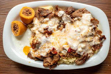 Local Turkish dish Iskender doner on an oval plate in slow motion