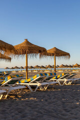Parasols and sunbeds on the beach of La Carihuela, Torremolinos, Costa del Sol.