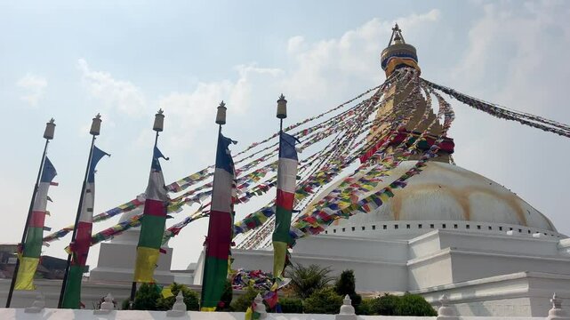 Dome of the largest Buddhist temple in Kathmandu. Many colourful flags with traditional prayers engraved on them, are waving