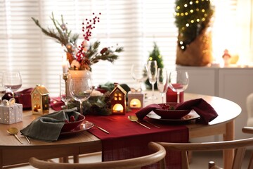 Christmas table setting with stylish dishware and festive decor indoors
