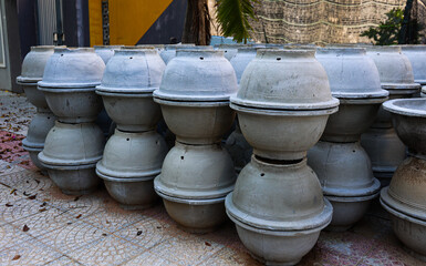 Obraz premium Stacks of gray concrete vessels on tiled surface outdoors