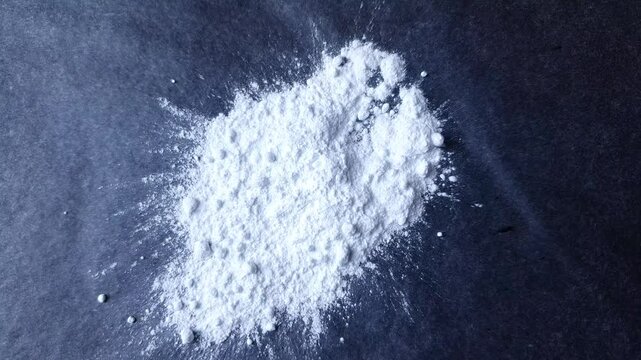 White drug, powder on black surface. Drug substance white powder concept.