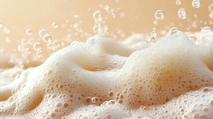 Obraz premium A wave of foam with bubbles of different sizes on a sandy-colored background