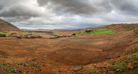 Nature scene in Connemara, Ireland with valley with fields, moorland, mountains and dramatic sky. Irish nature landscape. Travel and tourism. View from a high point