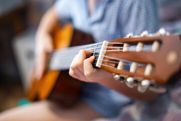 young child's hand clumsily presses guitar strings, embodying the spirit of learning and creativity. This moment captures the innocence and dedication of early musical exploration