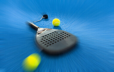 Black professional paddle tennis racket and ball with natural lighting on blue background....