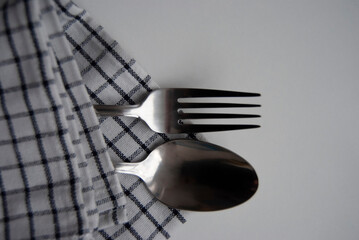 Dinner time. A fork and a spoon on a napkin. Cutlery isolated on white. 