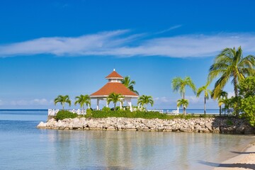A Gazebo near an ocean with blue water and rocks