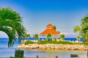 A Gazebo near an ocean with blue water and rocks