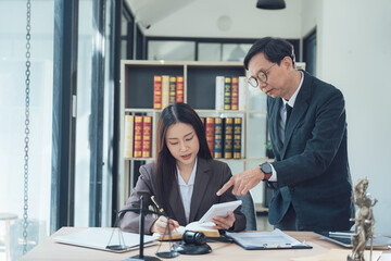 Lawyers Collaborating: Focused and professional, a male lawyer provides guidance to a female...