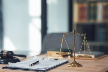 Scales of Justice: A close-up shot of a wooden desk with a gavel, a pen, legal documents, and a...